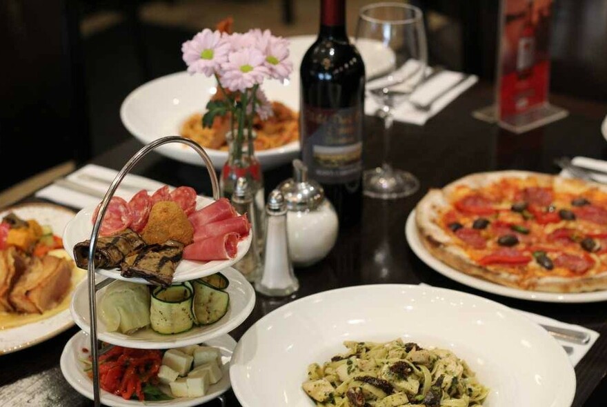 Antipasto, pizza and pasta at an Italian restaurant.