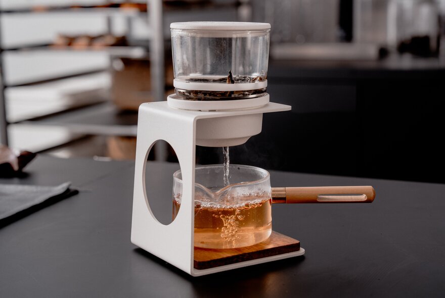 A drip coffee maker on a bench.