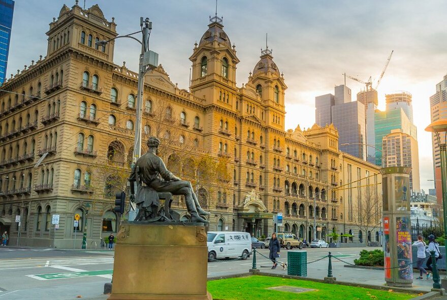 A statue with a large historic hotel in the background.