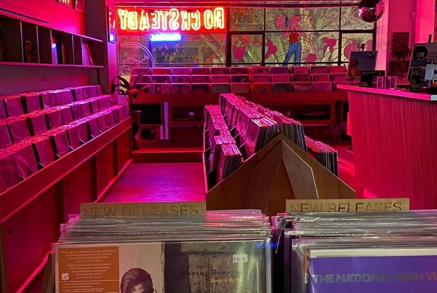 Record store illuminated by neon sign.