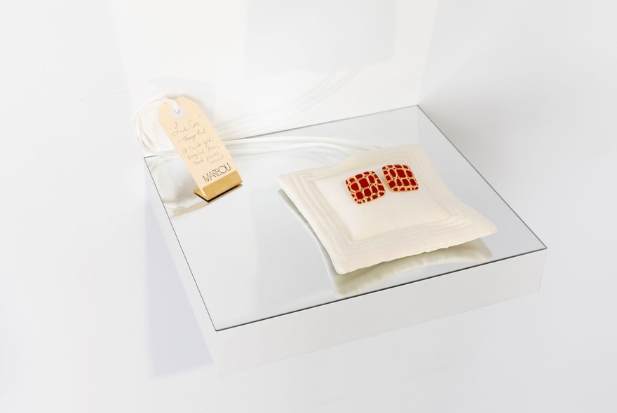 Gold earrings displayed on a white setting.