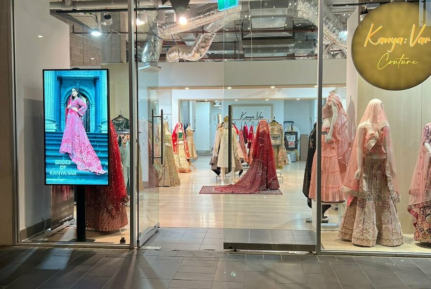 Glass shop front of Kanya Var boutique, showing mannequins in window and in store.