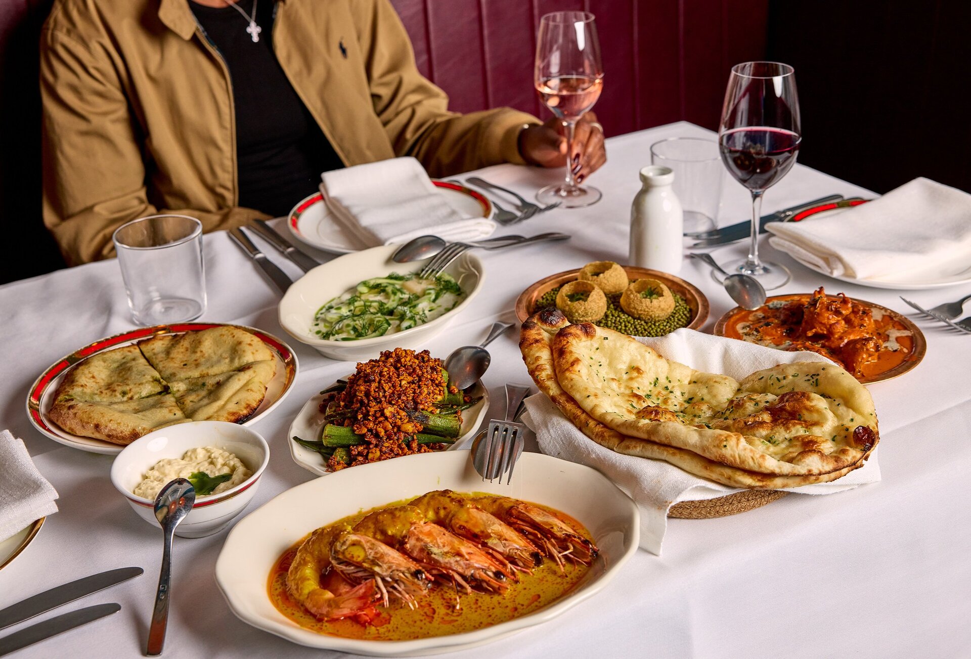Table set with Indian food and glasses of wine