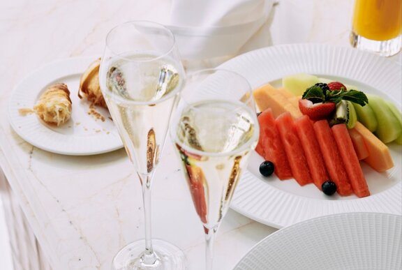 Glasses of champagne with fruit and pastries.