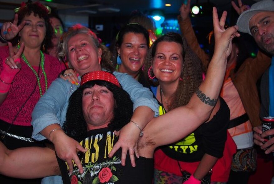 People wearing music T-shirts making peace signs and smiling for the camera.