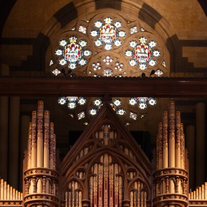 The organ pipes inside St Paul's Cathedral, with a circular stained glass window on the rear wall behind the organ.