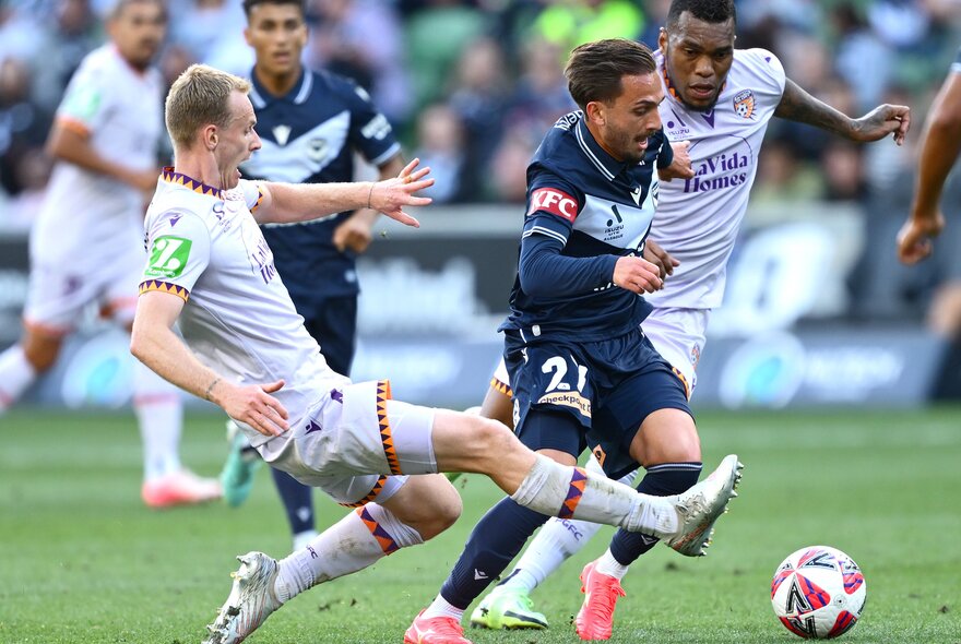 Soccer players kicking the ball during a match.