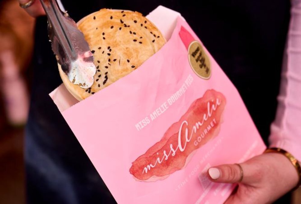 Pie being placed into baby pink bag.