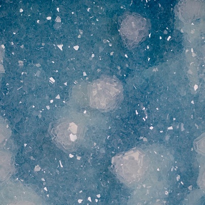 Artwork depicting a ghost-like image of a man appearing through blurred raindrop splatters in blue. 
