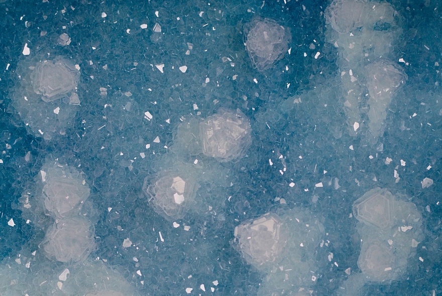 Artwork depicting a ghost-like image of a man appearing through blurred raindrop splatters in blue. 