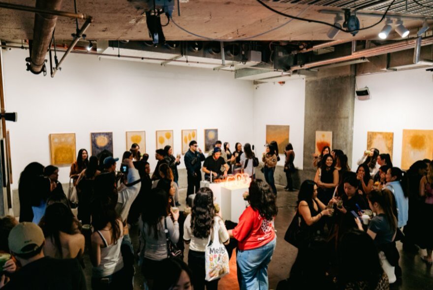 People dancing in a well-lit gallery space.