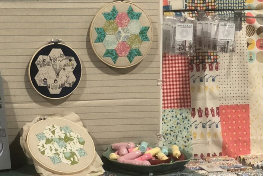 Examples of quilting techniques hanging on a wall next to fabric samples.