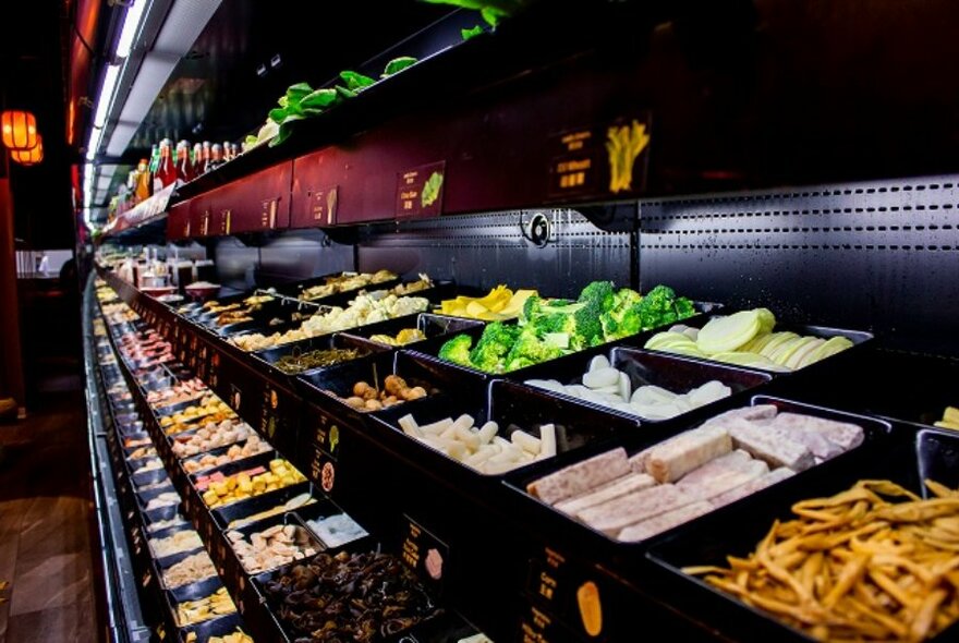 A long shelf of pre-cooked hot pot ingredients.