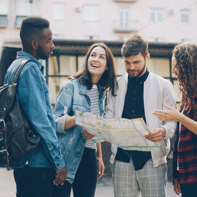 People holding a map in front of a tram.