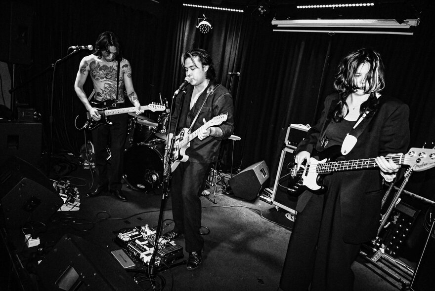 Band performing live on a small stage; black and white image.