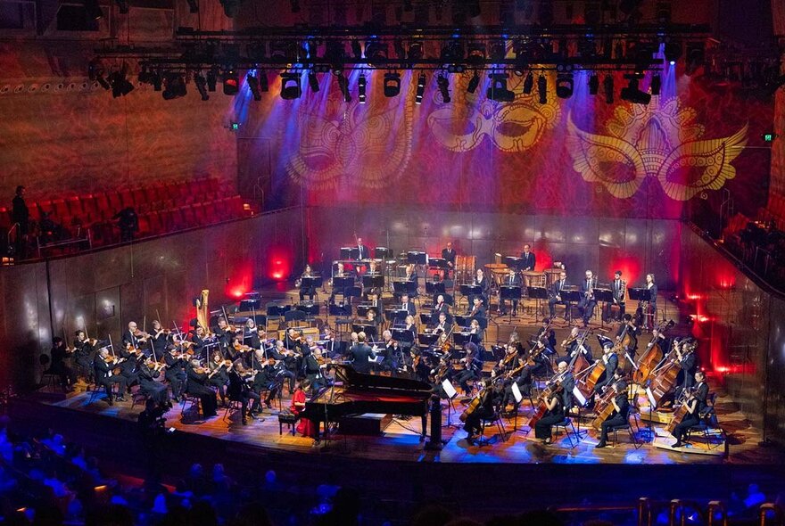The Melbourne Symphony Orchestra on stage, playing live to an audience.