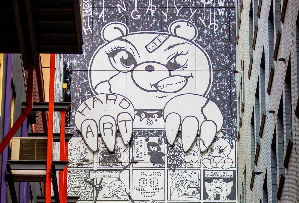 A street art mural designed to look like a comic book with a tough teddy bear.