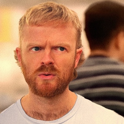 A young man with blond hair and a ginger beard, looking quizzically off camera.