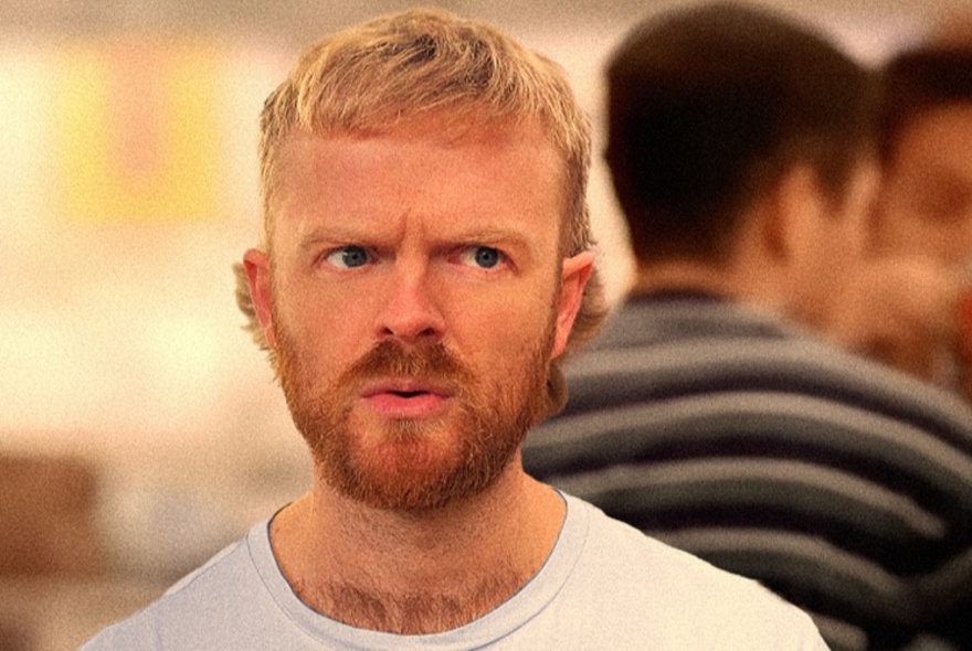 A young man with blond hair and a ginger beard, looking quizzically off camera.