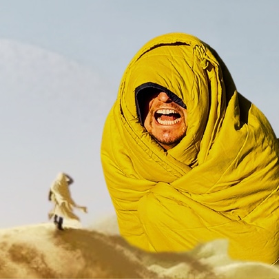 Dune-inspired image of a man wrapped in a yellow sleeping bag.