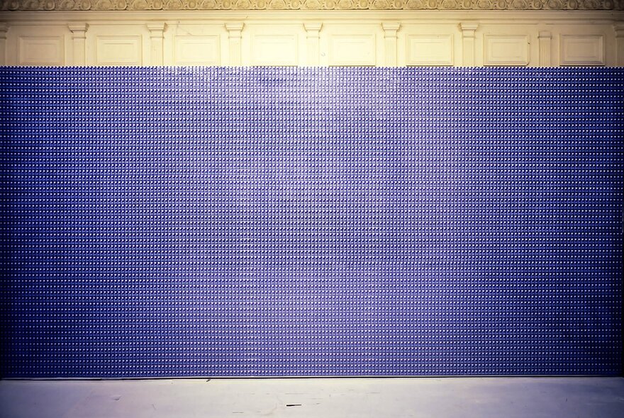 2000 Red Bull cans stacked against a wall in a gallery setting.