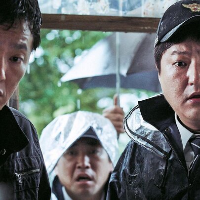 A still from a Korean horror film showing two police officers in shock.