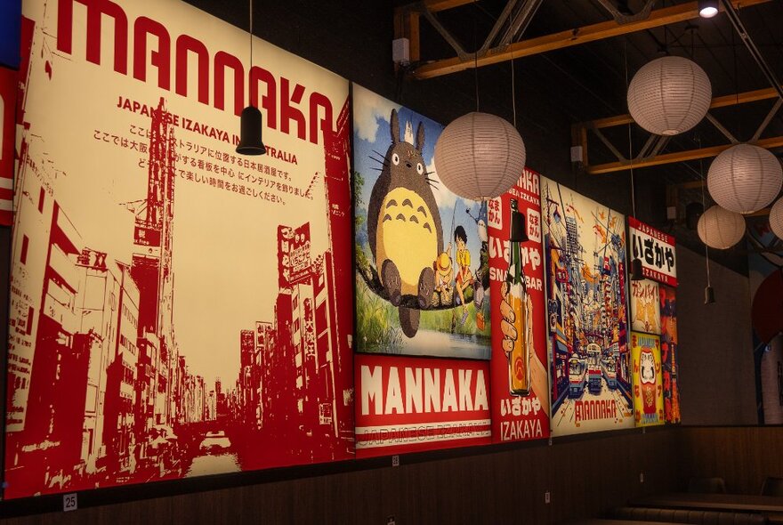 Signage in Mannaka Izakaya with lanterns above. 