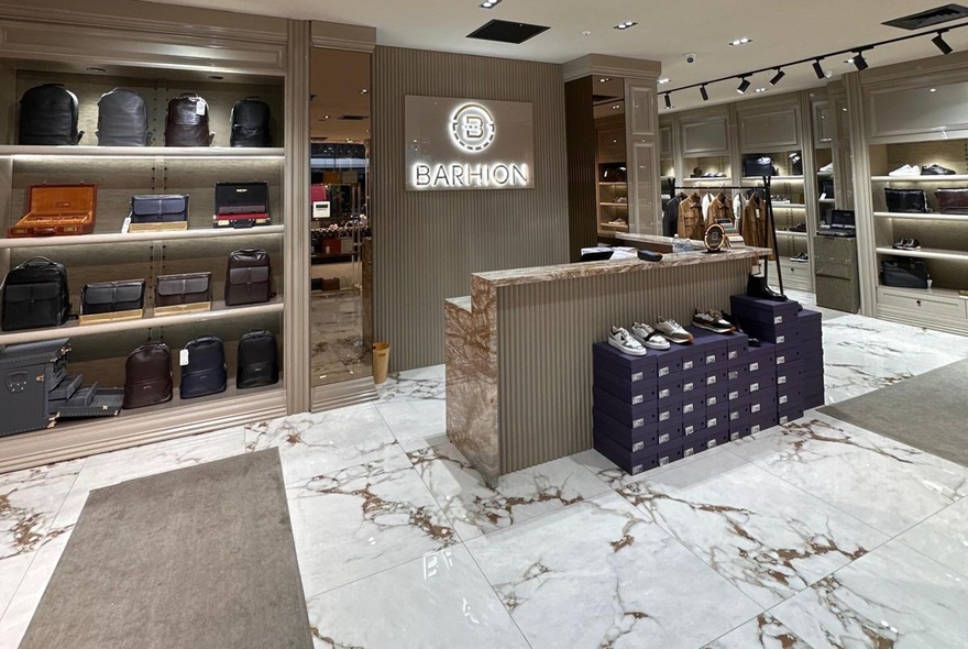 Retail store interior with shop counter and display shelves of leather goods.