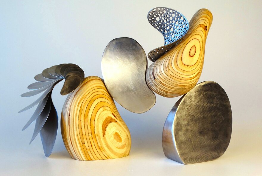 Dynamic sculpture shapes with the appearance of metal and woodgrain.