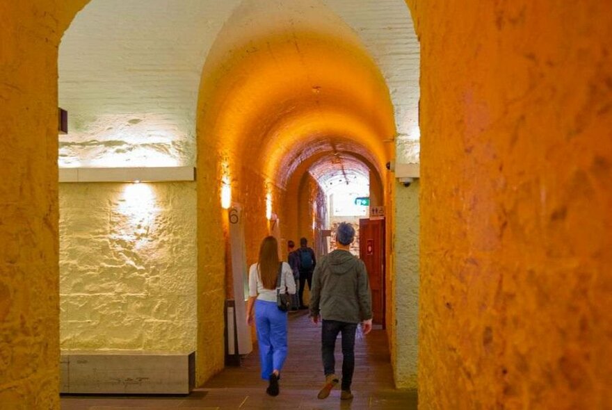 A couple walking in a domed hallway in a museum