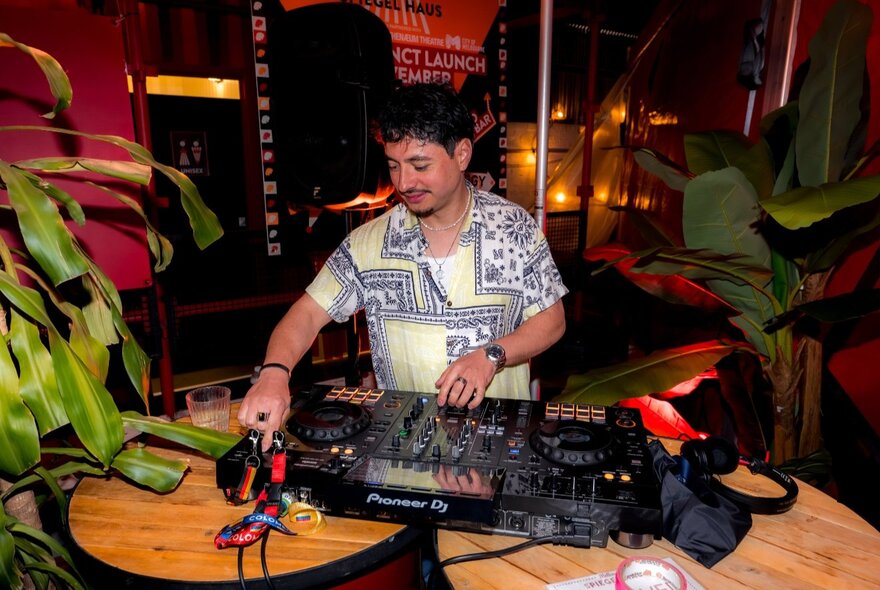 A DJ at a mixing desk during an event.
