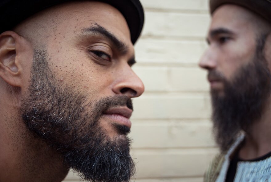 Two members of Cool Out Sun, one looking out of the corner of his eye menacingly. 
