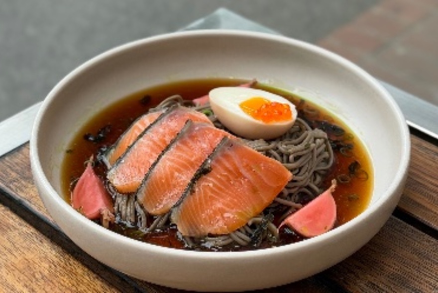 Seared salmon on soba noodles in broth with half an egg.