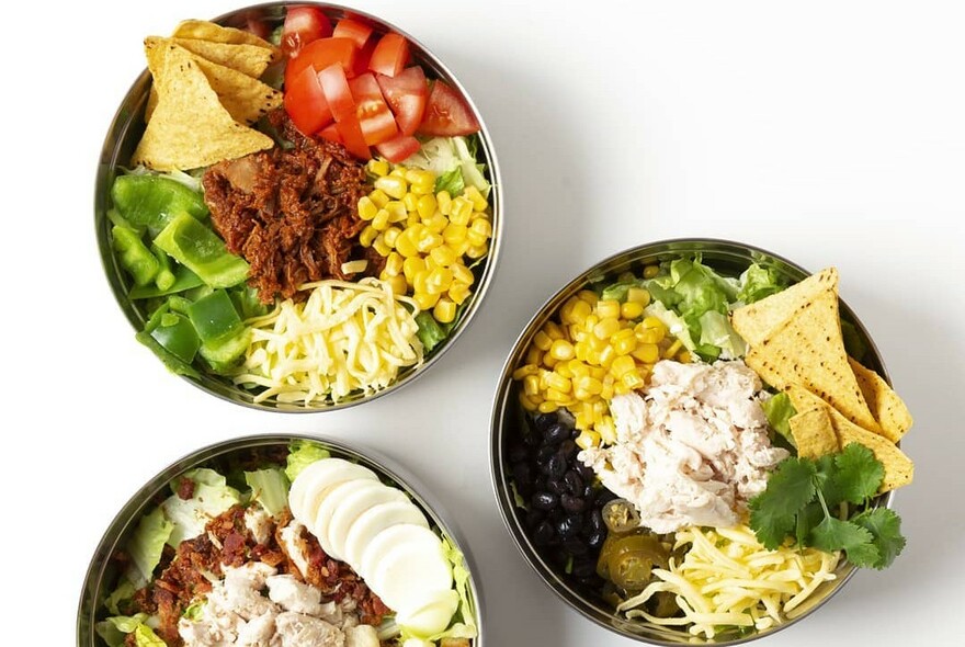 Bird's-eye view of several salad bowls.