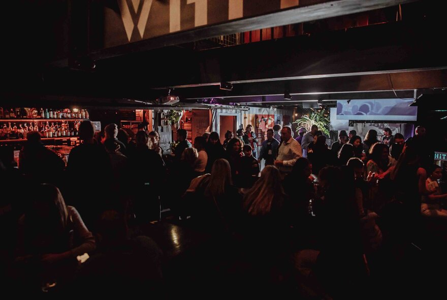 Crowded outside bar venue at night.