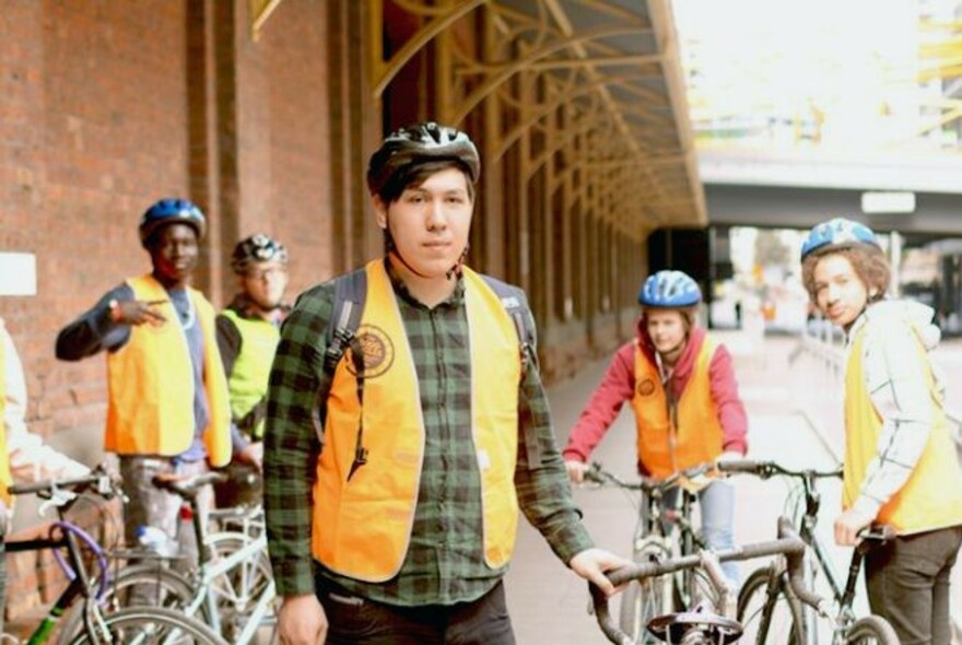 Group of people and their bicycles.