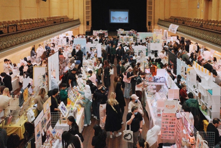 People shopping at an undercover art and stationery market, seen from above.