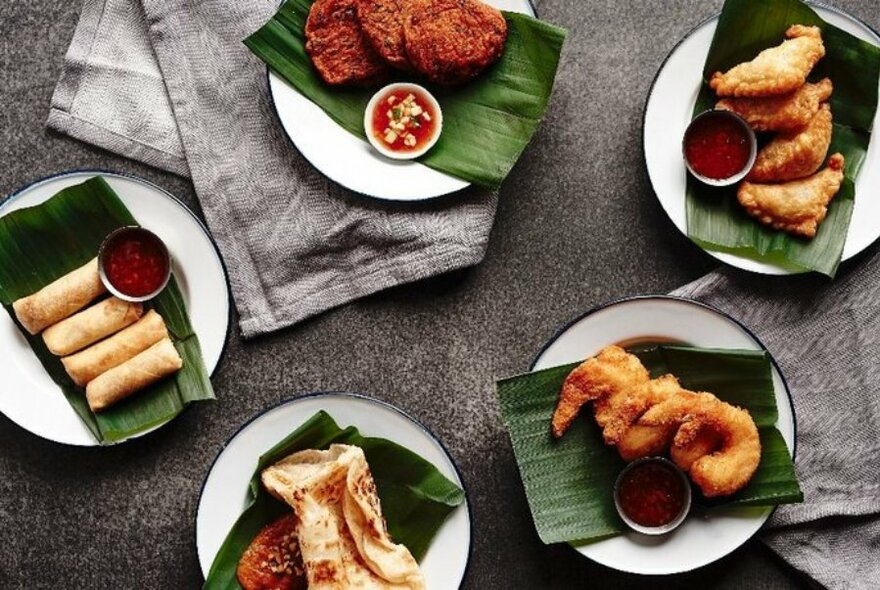 Various Thai entrees served on banana leaves.