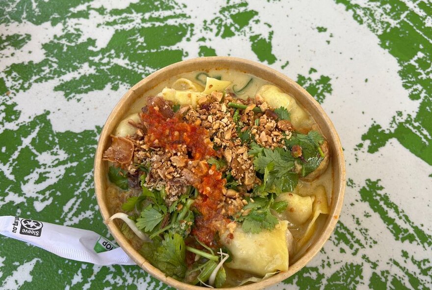 A bowl of Indonesian food on a table.