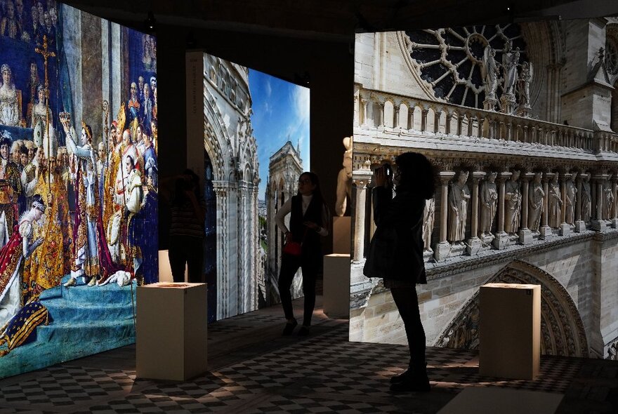 A museum patron using a HistoPad, an augmented reality device, to learn more about a historical artwork seen in front of her.