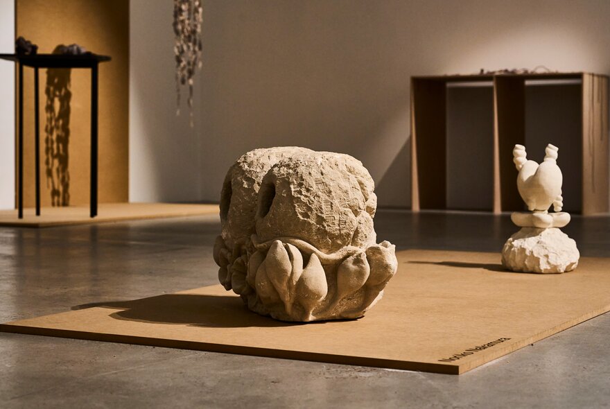 Large white free-standing abstract sculptures on floor display; an installation view of the exhibition In the Making at Craft Victoria's gallery space.