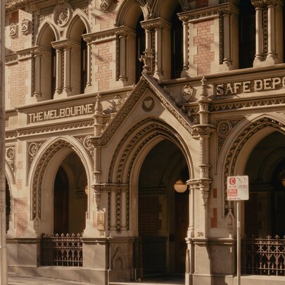 The ornate, Victorian Gothic facade of the Melbourne safe deposit building, featuring intricate stone archways and decorative carvings.