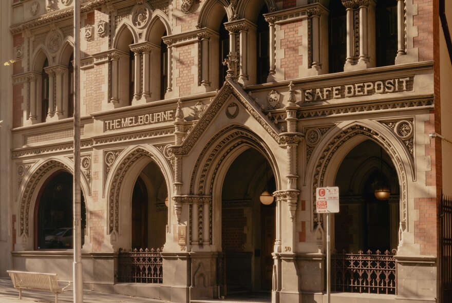 The ornate, Victorian Gothic facade of the Melbourne safe deposit building, featuring intricate stone archways and decorative carvings.