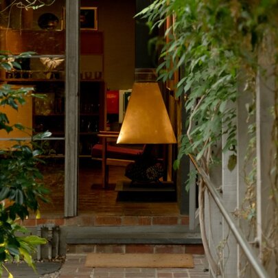Looking at a pathway with foliage leading up to a house with warm tones. 