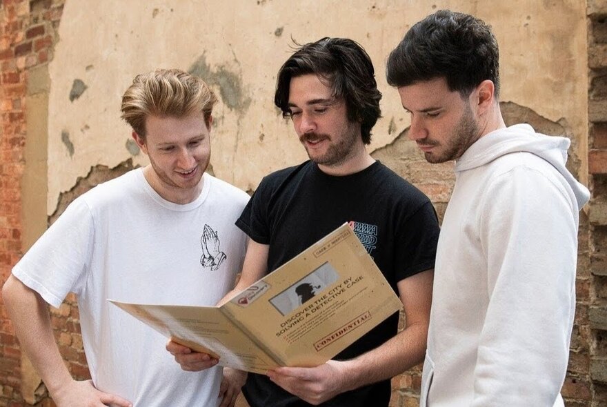 Participants with casebook paperwork looking for clues in the pages.