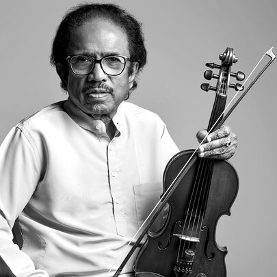 Black and white image of Dr. L. Subramaniam wearing a white shirt holding a violin.