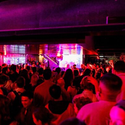 Red-lit dance crowd on a crowded dance floor.