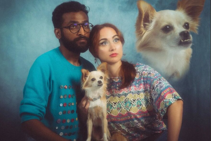 An awkward family photo with two people looking upwards right and holding a small dog - another dog with an underbite has been transposed in the right corner. 