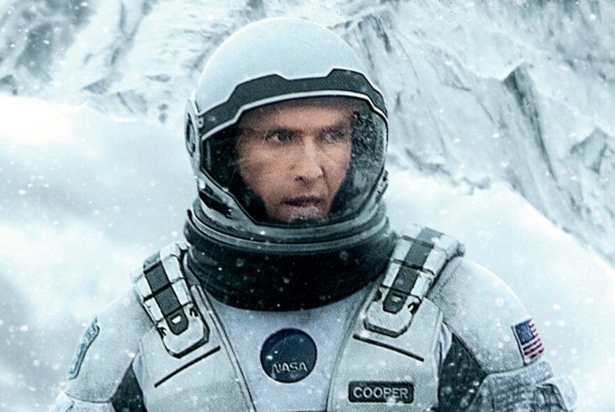 A still from the film, Interstellar, showing an astronaut in a white space suit on a snow-covered planet.