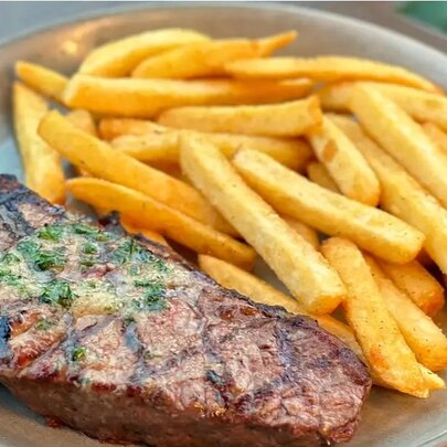 A steak on a plate with chips